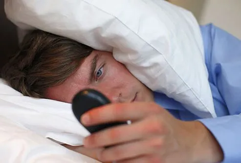 12_causes_od_fatigue_s1_man_checking_cellphone_in_bed.jpg